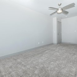 Carpeted bedoom with view of closet and door at North 49 Apartments, located in Colorado Springs, CO