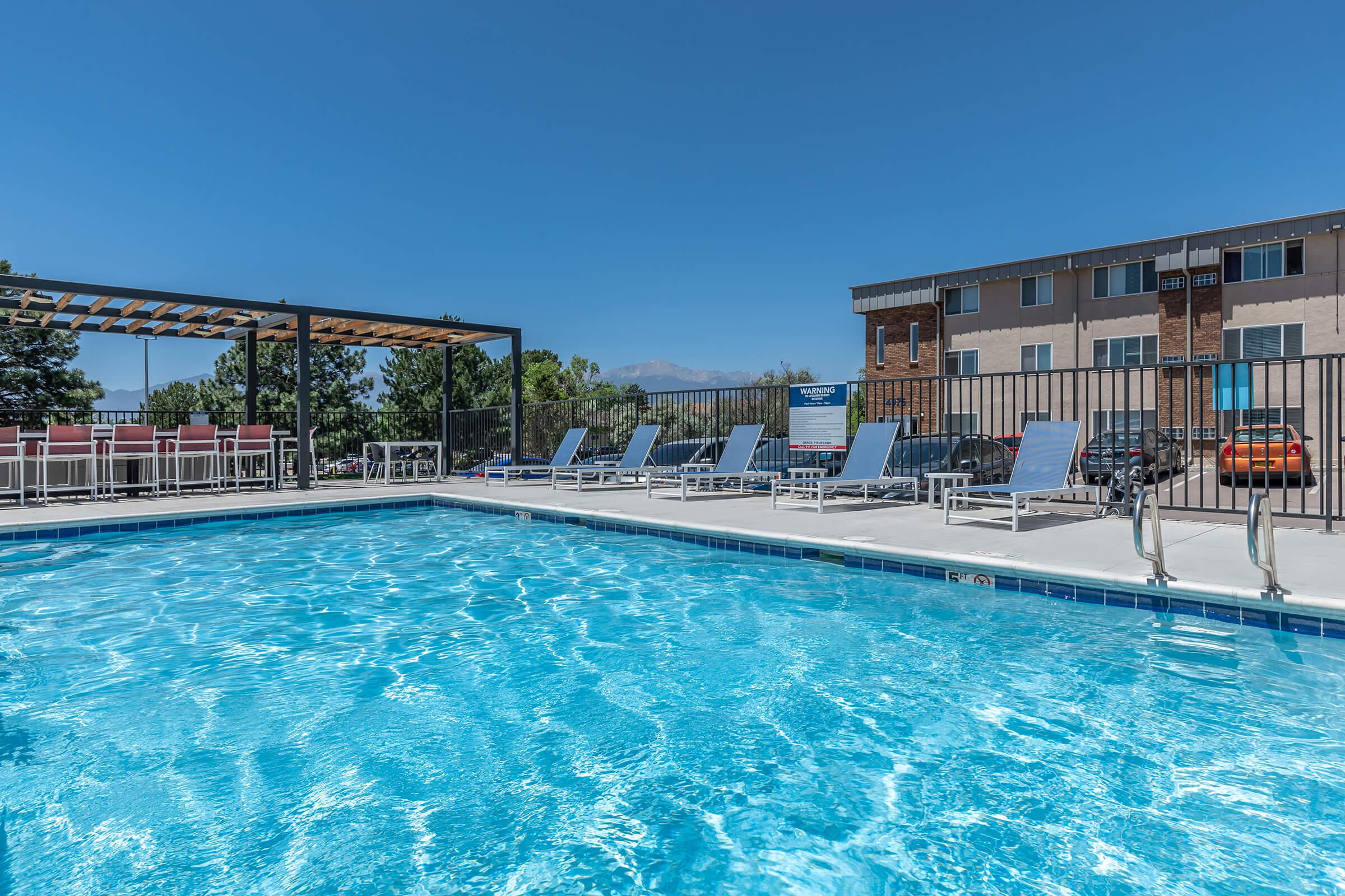 Swimming pool with lounge chairs at North 49 Apartments, located in Colorado Springs, CO